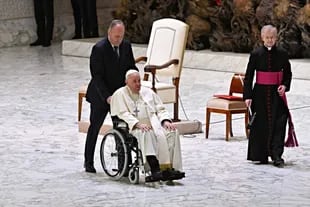 El Papa Francisco se traslada en una silla de ruedas cuando sale de una audiencia para entregar sus saludos navideños a los empleados del Vaticano en el Salón Pablo VI en el Vaticano el 22 de diciembre de 2022