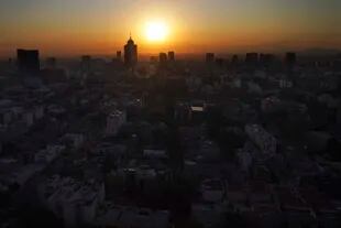 El sol sale detrás del World Trade Center, en el centro a la izquierda, en una mañana llena de smog en la Ciudad de México, el 31 de marzo de 2022.