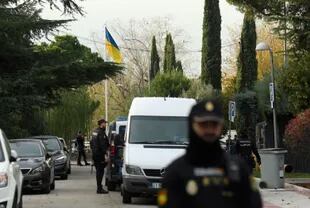 Policías españoles junto a una bandera ucraniana mientras aseguran la zona tras la explosión de una carta bomba en la embajada de Ucrania en Madrid el 30 de noviembre de 2022.