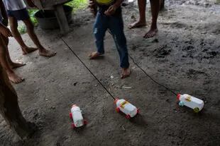 Niños juegan con autos hechos de botellas plásticas en Puerto Lempira
