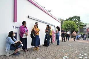 La gente hace cola en un colegio electoral en el Centro Universitario de Brasilia (UniCEUB) durante las elecciones legislativas y presidenciales, en Brasilia, Brasil, el 2 de octubre de 2022. - La votación comenzó el domingo temprano en la economía más grande de América del Sur, plagada de enormes desigualdades y violencia. , donde se espera que los votantes elijan entre el titular de extrema derecha Jair Bolsonaro y el favorito de izquierda Luiz Inacio Lula da Silva, cualquiera de los cuales debe obtener el 50 por ciento de los votos válidos, más uno, para ganar en la primera vuelta. (Foto por EVARISTO SA / AFP)