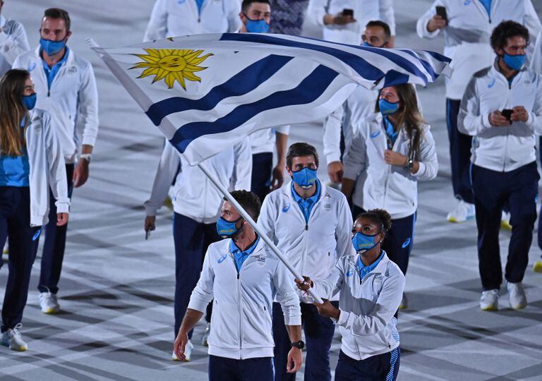 La abanderada de Uruguay Deborah Rodríguez y el abanderado de Uruguay Bruno Cetraro Berriolo encabezan la delegación durante la ceremonia inaugural de los Juegos Olímpicos de Tokio 2020.