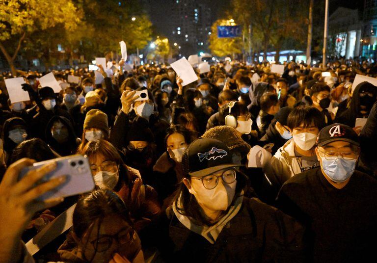 Manifestantes marchan a lo largo de una calle durante una concentración en favor de las víctimas de un incendio mortal, así como una protesta contra las duras restricciones Covid-19 de China, en Pekín, el 28 de noviembre de 2022. 