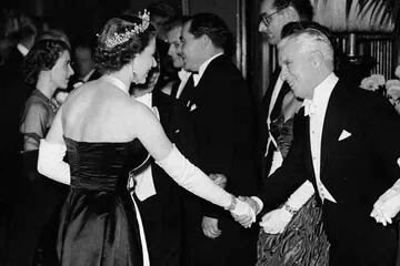 La reina Isabel II le da la mano al actor Charlie Chaplin en el Empire Theatre de Londres el 27 de octubre de 1952 para el Royal Film Show, una actuación benéfica para ayudar al Cinematograph Trade Benevolent Fund