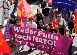 Activistas sostienen una pancarta en la que se lee "Ni Putin ni la OTAN. Contra la guerra y el rearme" mientras marchan durante una manifestación previa a la reunión del G7 en Múnich, Alemania, el sábado 25 de junio de 2022.