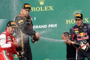 Gran Premio de Australia 2013: Fernando Alonso (Ferrari) y Sebastian Vettel (Red Bull) flanquean en el festejo al ganador Kimi Raikkonen (Lotus); la escudería inglesa contrató al finlandés para su regreso a la categoría en 2012