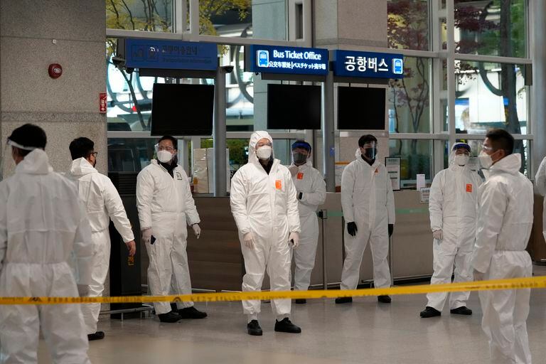 Funcionarios de cuarentena esperan para conducir a los viajeros en la sala de llegadas del Aeropuerto Internacional de Incheon, en Incheon, Corea del Sur, el miércoles 1 de diciembre de 2021. (AP Foto/Ahn Young-joon)