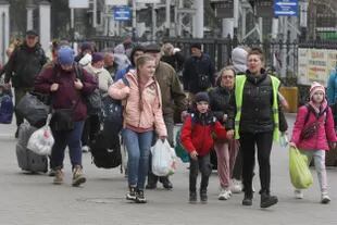 Refugiados de Mikolaiv y regiones cercanas llegan durante su evacuación a la estación de tren de Odessa, Ucrania, el 16 de abril de 2022.