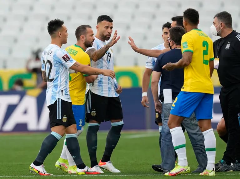 Jugadores de Brasil y Argentina hablan mientras las autoridades sanitarias interrumpen el partido