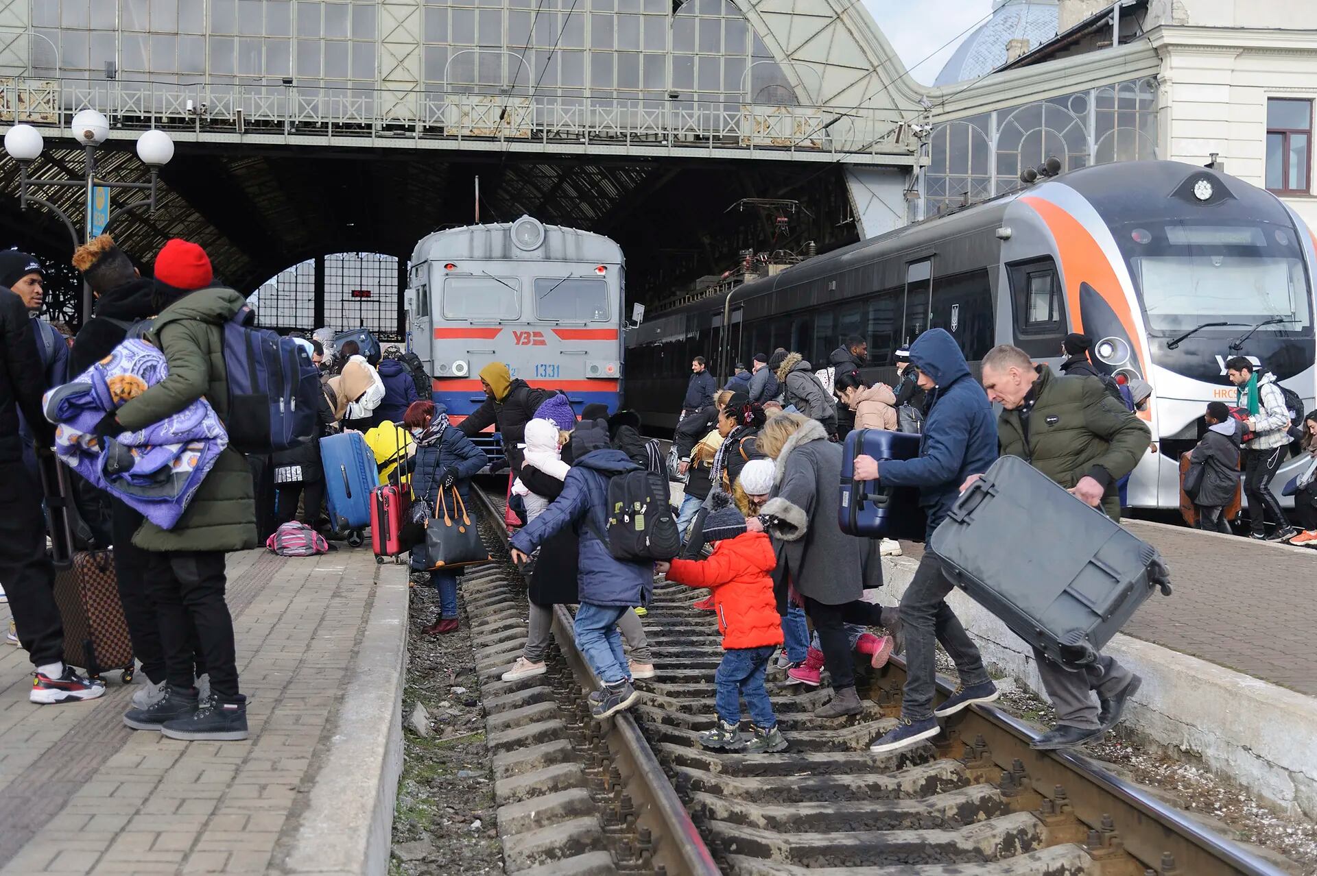 La gente se reúne para tomar un tren y salir de Ucrania hacia los países vecinos en la estación ferroviaria de Lviv, en el oeste de Ucrania.