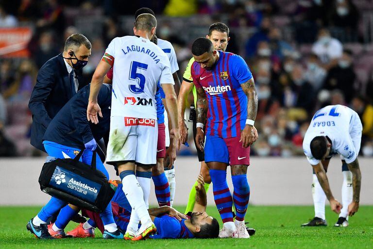 El Kun Agüero, tendido sobre el césped, durante el partido entre Barcelona y Alavés; se toca el pecho, mientras lo observa Depay