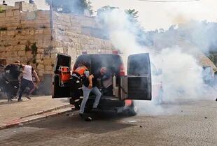 Los médicos palestinos evacuan a los manifestantes heridos mientras las fuerzas de seguridad israelíes disparan gases lacrimógenos en la Ciudad Vieja de Jerusalén 