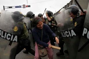 Partidarios del expresidente Pedro Castillo confrontan a policías antidisturbios que rodean la comisaría a la que llegó Castillo en Lima, Perú, el miércoles 7 de diciembre de 2022. (AP Foto/Martín Mejía)