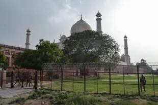 Miembros del personal de seguridad montan guardia detrás de una valla perimetral en el Taj Mahal