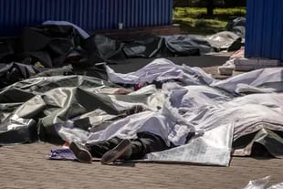 EDITORS NOTE: Graphic content / Bodies are covered with plastic sheets after a rocket attack killed at least 35 people on April 8, 2022 at a train station in Kramatorsk, eastern Ukraine, that was being used for civilian evacuations. (Photo by FADEL SENNA / AFP)