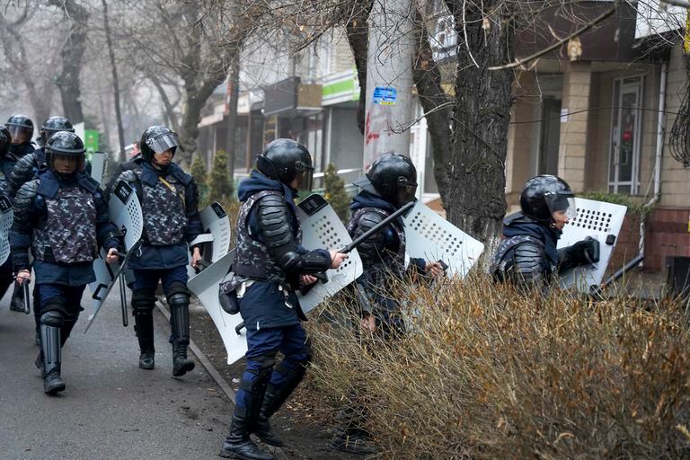 Policías antimotines tratan de cortar el paso a manifestantes durante una protesta en Almaty, Kazajistán, el 5 de enero de 2022. (AP Foto/Vladimir Tretyakov)
