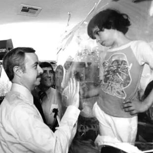 William Shearer, médico personal de David Vetter, visita a su joven paciente en 1979