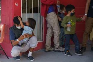 Migrantes esperan fuera del gimnasio Kiki Romero, convertido en un lugar de refugio en Ciudad Juárez, luego de ser expulsados desde Estados Unidos hacia México