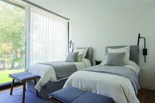 En el cuarto que comparten los varones, camas estilo ‘Ghost’ en lino gris, acolchado de tussor y almohadones en el mismo color (todo de Andy Forn Casa). Banquetas ‘Neo’ (Habito) Alfombra (Mihran).