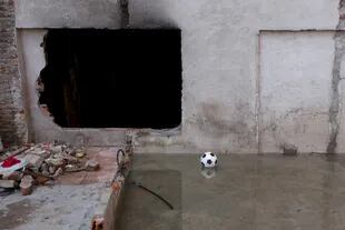 Una pelota de fútbol sobre un charco de agua cloacal estancada, al lado de la casa de uno de los vecinos del Elefante