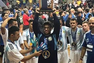 Javier Fernández arquero de la Selección Argentina de Futsal Síndrome de Down levanta el trofeo de sub campeón, conseguido anoche en Brasil