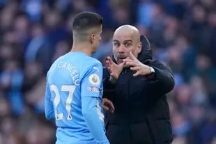 Pep Guardiola, DT de Manchester City, le da instrucciones a Joao Cancelo en un partido de la Premier League
