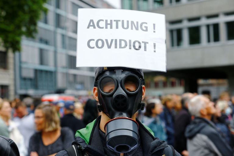 Un manifestante con una máscara tiene un cartel pegado a su cabeza durante una protesta contra las medidas del gobierno suizo para frenar la propagación de la enfermedad del coronavirus (COVID-19), en la plaza Helvetiaplatz en Zurich, Suiza,