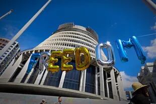 Esta foto tomada el 15 de febrero de 2022 muestra globos ensartados con la leyenda "libertad", frente al parlamento del país (detrás) en Wellington, en el octavo día de manifestaciones contra las restricciones de Covid-19. 