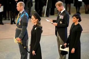 El príncipe británico Guillermo, Kate, la princesa de Gales, el príncipe Harry, y su esposa Meghan, la duquesa de Sussex, presentan sus respetos a la reina Isabel II mientras el féretro descansa en Westminster Hall para su entierro, en Londres, el miércoles 14 de septiembre de 2022. 