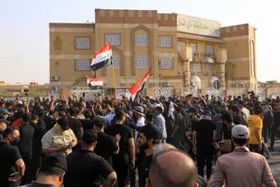Los partidarios del clérigo chiíta iraquí Moqtada Sadr cantan consignas mientras se reúnen frente a la sede del gobierno local en la ciudad de Nasiriyah, en la provincia de Dhi Qar, en el sur de Irak, el 29 de agosto de 2022