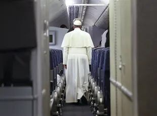 Francisico camina por el avión durante el vuelo que lo llevó de regreso a Roma