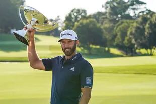 Dustin Johnson celebra con el trofeo de la Copa FedEx después de ganar el torneo de golf Tour Championship el lunes 7 de septiembre de 2020 en Lake Golf Club en Atlanta.