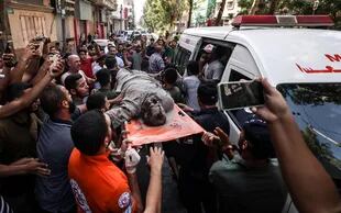 El cuerpo de un palestino en Gaza tras el ataque israelí. (Photo by MAHMUD HAMS / AFP)