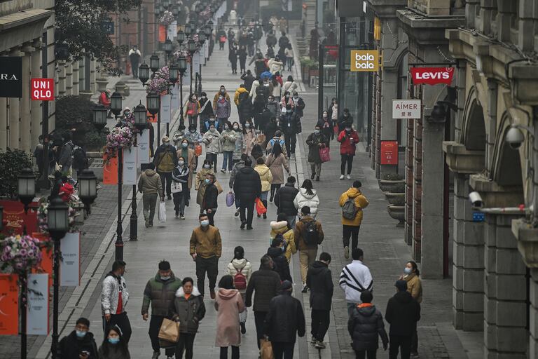La gente camina por una calle peatonal en Wuhan, provincia central de Hubei en China, el 23 de enero de 2021, un año después de que la ciudad se cerrara para frenar la propagación del coronavirus
