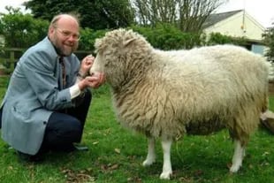 Foto cedida por la Universidad de Edimburgo en la que se ve a la oveja Dolly acariciada por su creador, el británico Ian Wilmut