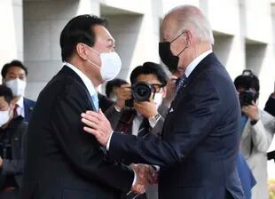 El presidente surcoreano Yoon Suk Yeol, a la izquierda, saluda al mandatario estadounidense Joe Biden antes de su reunión en la Casa del Pueblo en Seúl, Corea del Sur, el 21 de mayo de 2022. (Song Kyung-Seok/Foto compartida vía AP)