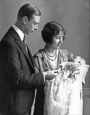 En esta foto de archivo tomada en 1926, Lady Elizabeth Angela Marguerite Bowes-Lyon, hija del decimocuarto conde de Strathmore, la duquesa de York (derecha), y su esposo, el príncipe George, duque de York, sostienen a su hija, la princesa Isabel, futura reina de Gran Bretaña