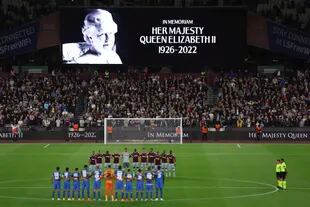 En esta imagen del 8 de septiembre, los futbolistas de West Ham y FCSB Steaua Bucharest guardan un minuto de silencio por la muerte de la reina Isabel II de Inglaterra antes de un partido del Grupo B de la Europa League, en Londres. 