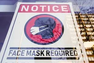 ARCHIVO - Un letrero avisa sobre el uso obligatorio de la mascarilla para impedir la propagación del coronavirus afuera de una tienda en Filadelfia, el 16 de febrero de 2022. (AP Foto/Matt Rourke, Archivo)