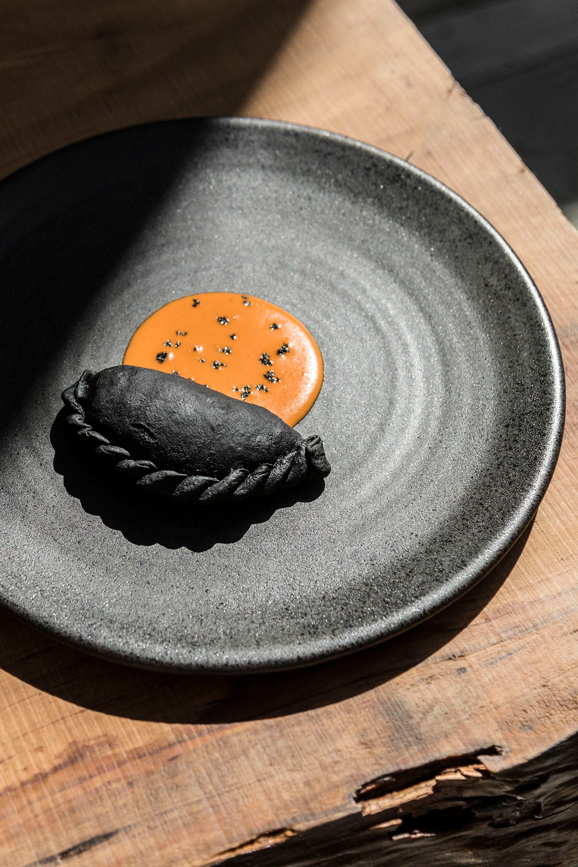 La empanada de carbón de Sacro, uno de sus platos más legendarios y distintivos.
