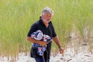 Alec Baldwin es visto abatido caminando por la playa de The Hamptons, en Nueva York, horas después de que el informe forense del FBI concluya que el actor apretó el gatillo en el set de Rust