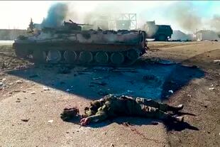 Imagen tomada de un video publicado por el Servicio de Prensa del Departamento de Policía de Ucrania, el cuerpo de un soldado muerto yace en el suelo junto a vehículos militares destrozados.(Servicio de Prensa del Departamento de Policía de Ucrania vía AP)