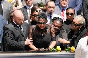 Amigos y familiares consuelan a Kalabrya Haskins, centro, la viuda del exquarterback de los Steelers de Pittsburgh Dwayne Haskins, en su funeral, el viernes 22 de abril de 2022, en Pittsburgh. (AP Foto/Keith Srakocic)