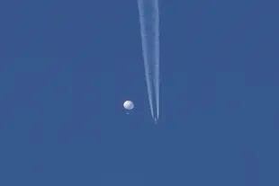 El globo chino, al pasar sobre la zona de Kingstown, Carolina del Norte, mientras por debajo se observa un avión y la estela que deja a su paso. (Brian Branch vía AP)