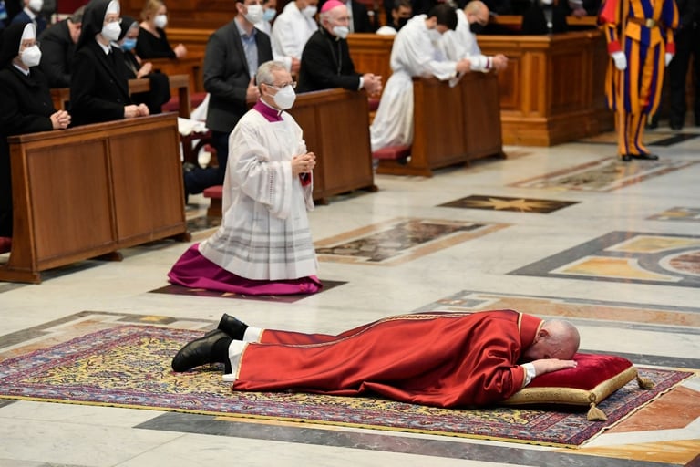 El Papa postrado durante la ceremonia
