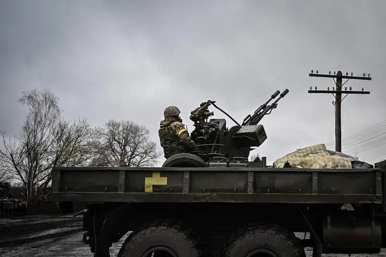 Un soldado ucraniano mantiene su posición sentado en un cañón antiaéreo ZU-23-2 en una línea del frente, al noreste de Kiev el 3 de marzo de 2022. - Un negociador ucraniano que se dirigía a las conversaciones de alto el fuego con Rusia dijo el 3 de marzo de 2022 que su objetivo estaba asegurando los corredores humanitarios, mientras las tropas rusas avanzan una semana después de su invasión de Ucrania.  (Foto de Aris Messinis / AFP)