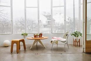Mesa ‘Ostende’, silla blanca Eames y banco ‘Esteban’ (todo de Unimate). Manta con flecos de Elementos Argentinos.