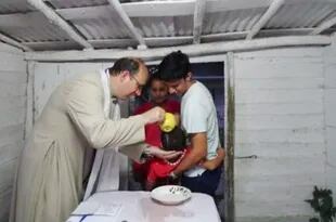 El padre Jorge Herrera, que acompaña al padre Carlos Peteira, en la misión de Yaguajay, celebra un bautismo