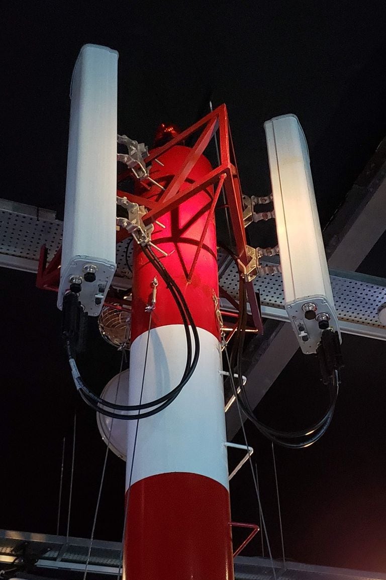 Una antena de telefonía celular y el equipamiento que usan los operarios para montar las redes