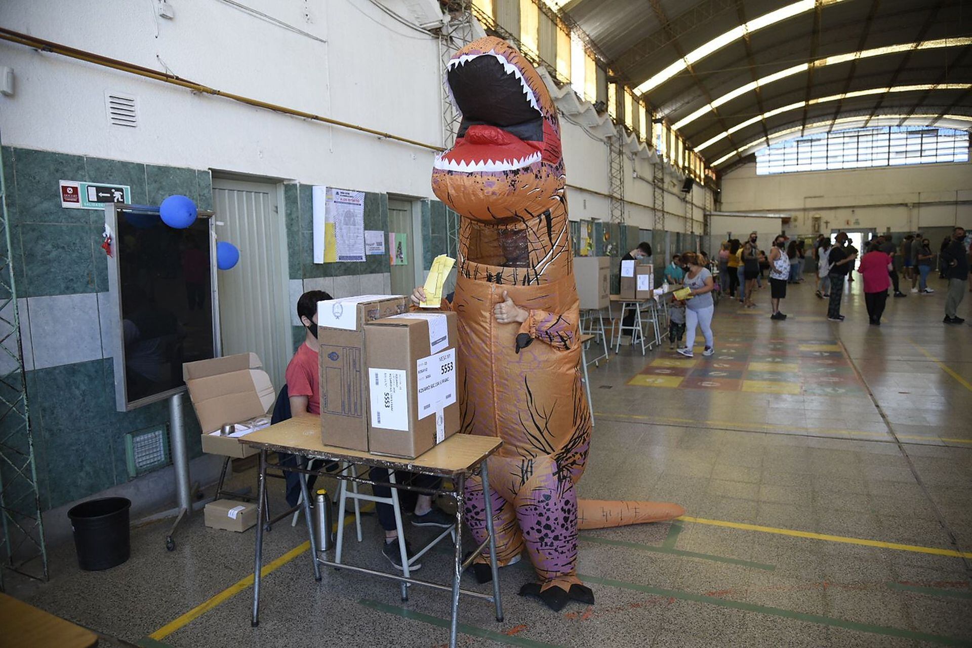 Un tiranosaurio votando en una escuela de Rosario